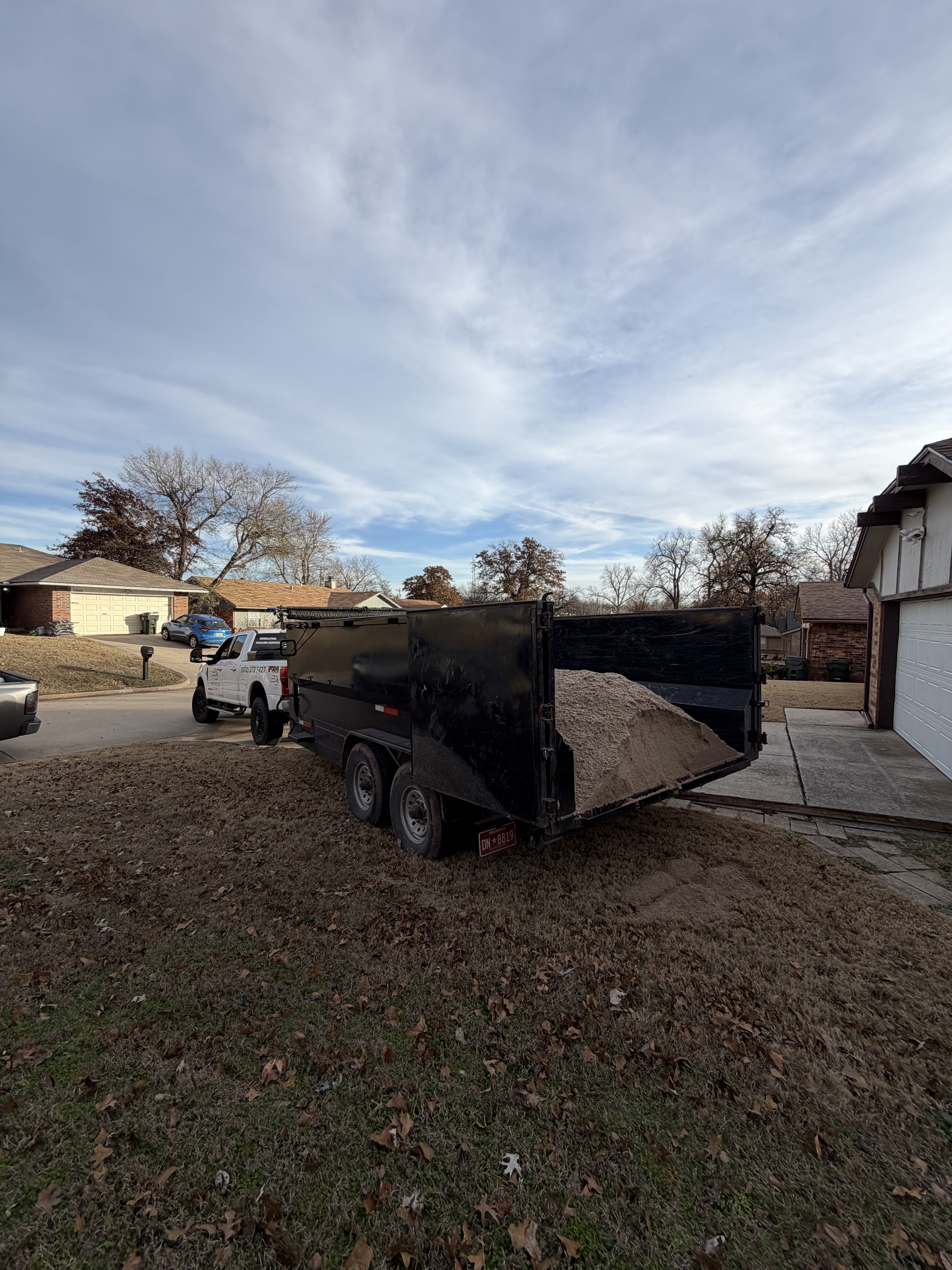 Appliance hauling and junk removal serviceBig Project Solutions dump trailer unloading gravel for landscaping in Oklahoma City residential driveway
